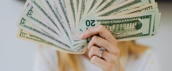 pexels-photo-4968649-4968649 A person holding a fan of US dollar bills, symbolizing wealth and financial success.