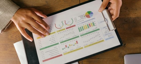 Top view of hands holding a financial report with colorful graphs and charts, ideal for business presentations.